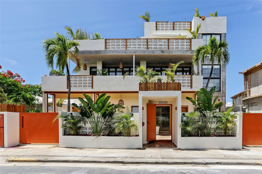 A three-story white building with orange gates, decorative breeze blocks, and tropical landscaping — 2061 CACIQUE, SAN JUAN, PR