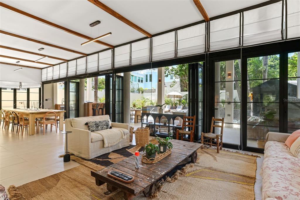 A living room with a wooden coffee table, beige sofa, and large glass folding doors — 2061 CACIQUE, SAN JUAN, PR