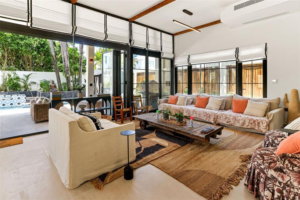 A bright living room features large glass doors opening to a patio with a pool — 2061 CACIQUE, SAN JUAN, PR