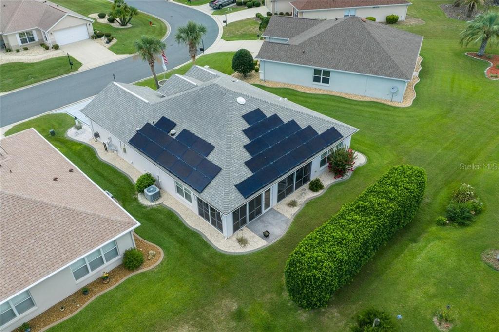 An aerial view of a suburban house with solar panels installed on the roof — 9203 SE 118TH LOOP, SUMMERFIELD, FL