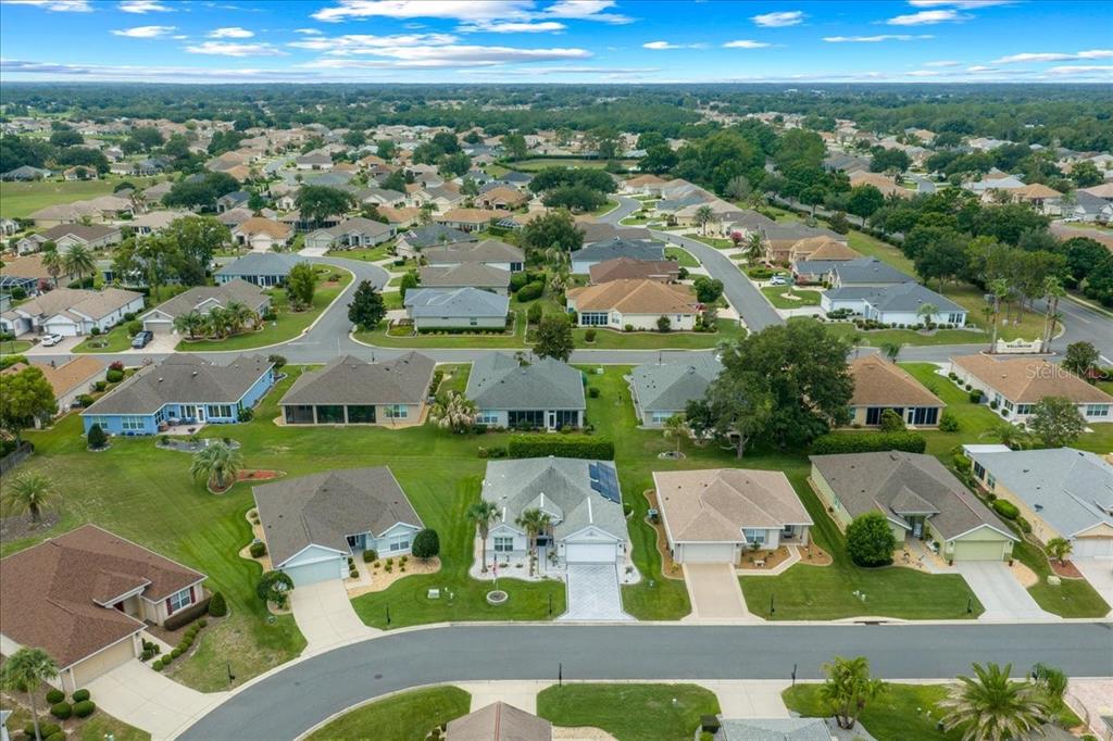 An aerial view of a suburban neighborhood featuring single-family homes with driveways and green lawns — 9203 SE 118TH LOOP, SUMMERFIELD, FL