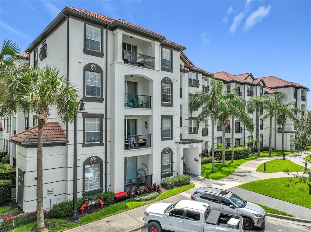 A multi-story apartment building with stucco walls, tile roofs, and balconies under a blue sky — 4024 BREAKVIEW DRIVE UNIT 20904, ORLANDO, FL
