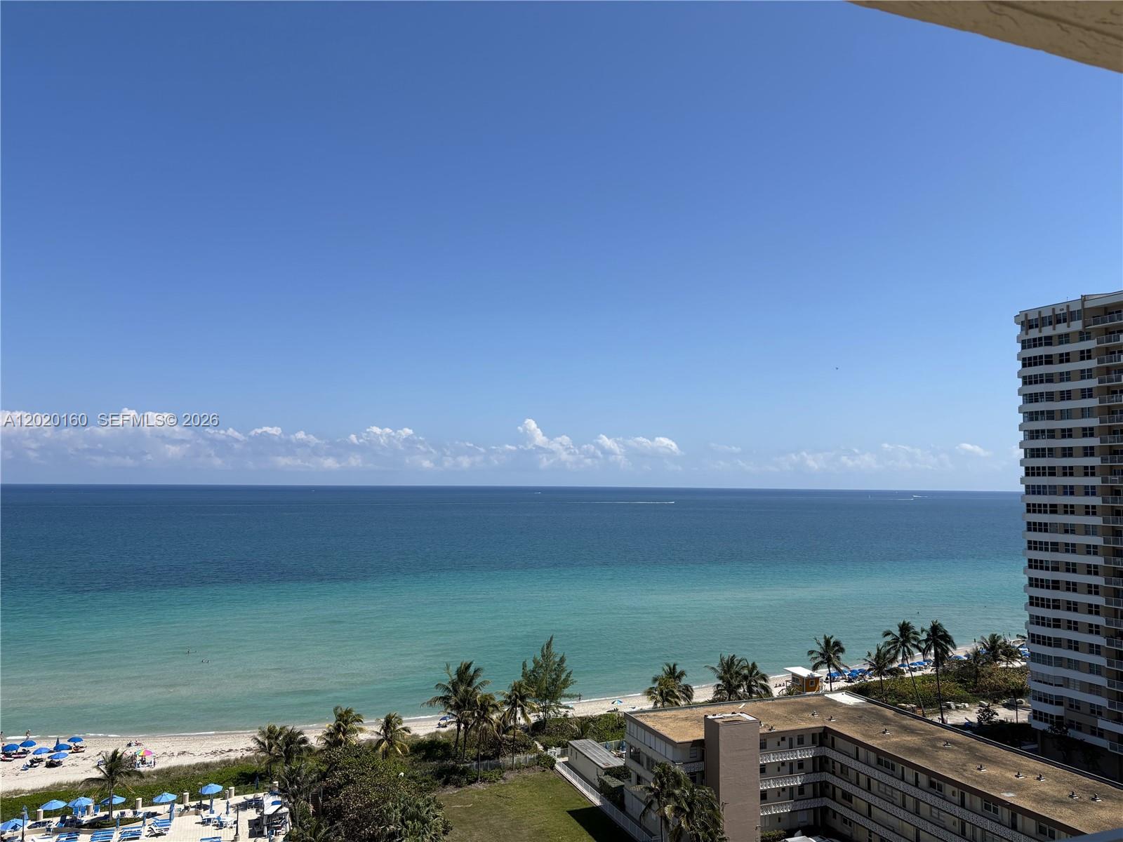 A high-angle view shows a sandy beach, turquoise ocean, and nearby residential buildings — 1920 S Ocean Dr # 16B, Hallandale Beach FL 33009, HALLANDALE BEACH, FL