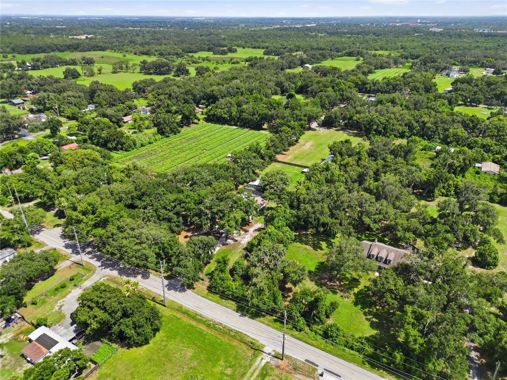 An aerial view shows a rural property with a house, trees, and a large field — 2709 W SAM ALLEN ROAD, PLANT CITY, FL