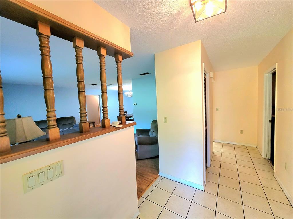 A tiled hallway leads past a half-wall with wooden spindles into a living area — 19725 SW BEACH BOULEVARD, DUNNELLON, FL