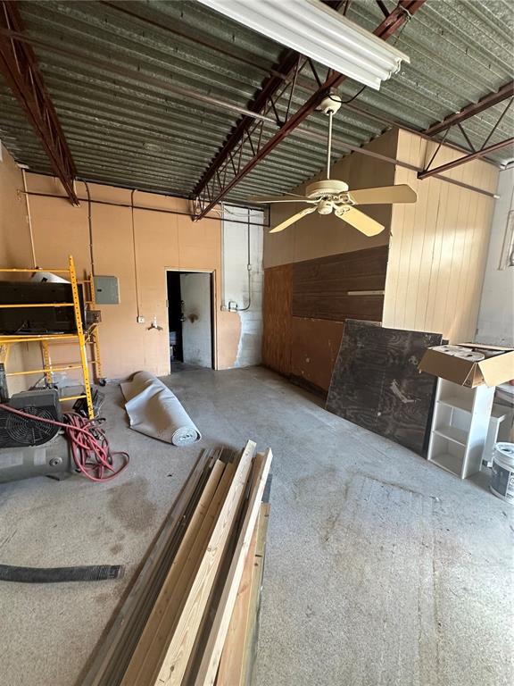 An unfinished industrial-style room features exposed metal ceiling joists, a ceiling fan, and concrete flooring — 2254 S TAMIAMI TRAIL, VENICE, FL