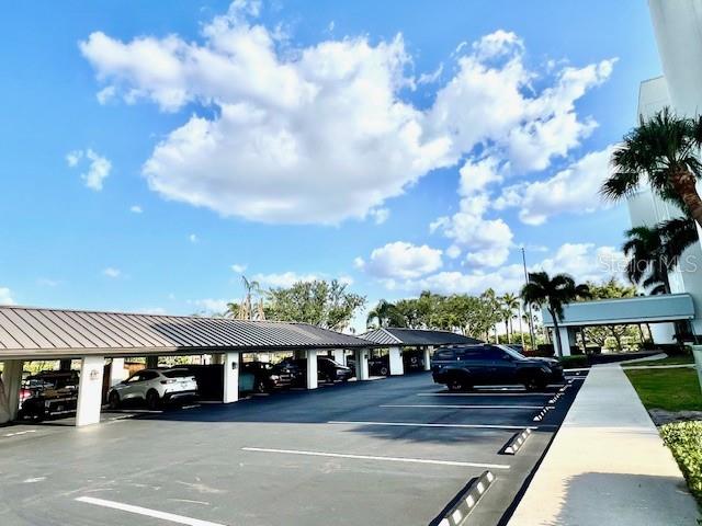 A low-angle exterior view of a multi-story apartment building with palm trees and a flag — 3020 MATECUMBE KEY ROAD UNIT 103, PUNTA GORDA, FL