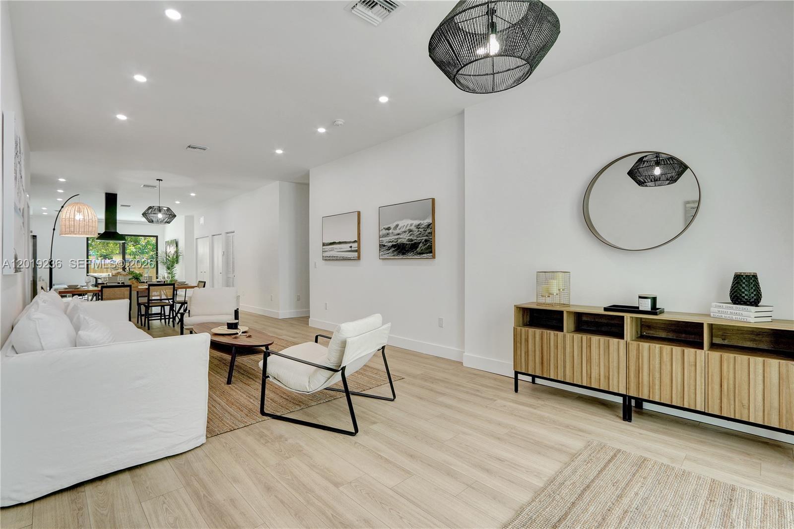 A bright, open-concept living room features white walls, light wood flooring, and modern furniture — 2001 SW 22nd Ter, Miami FL 33145, MIAMI, FL