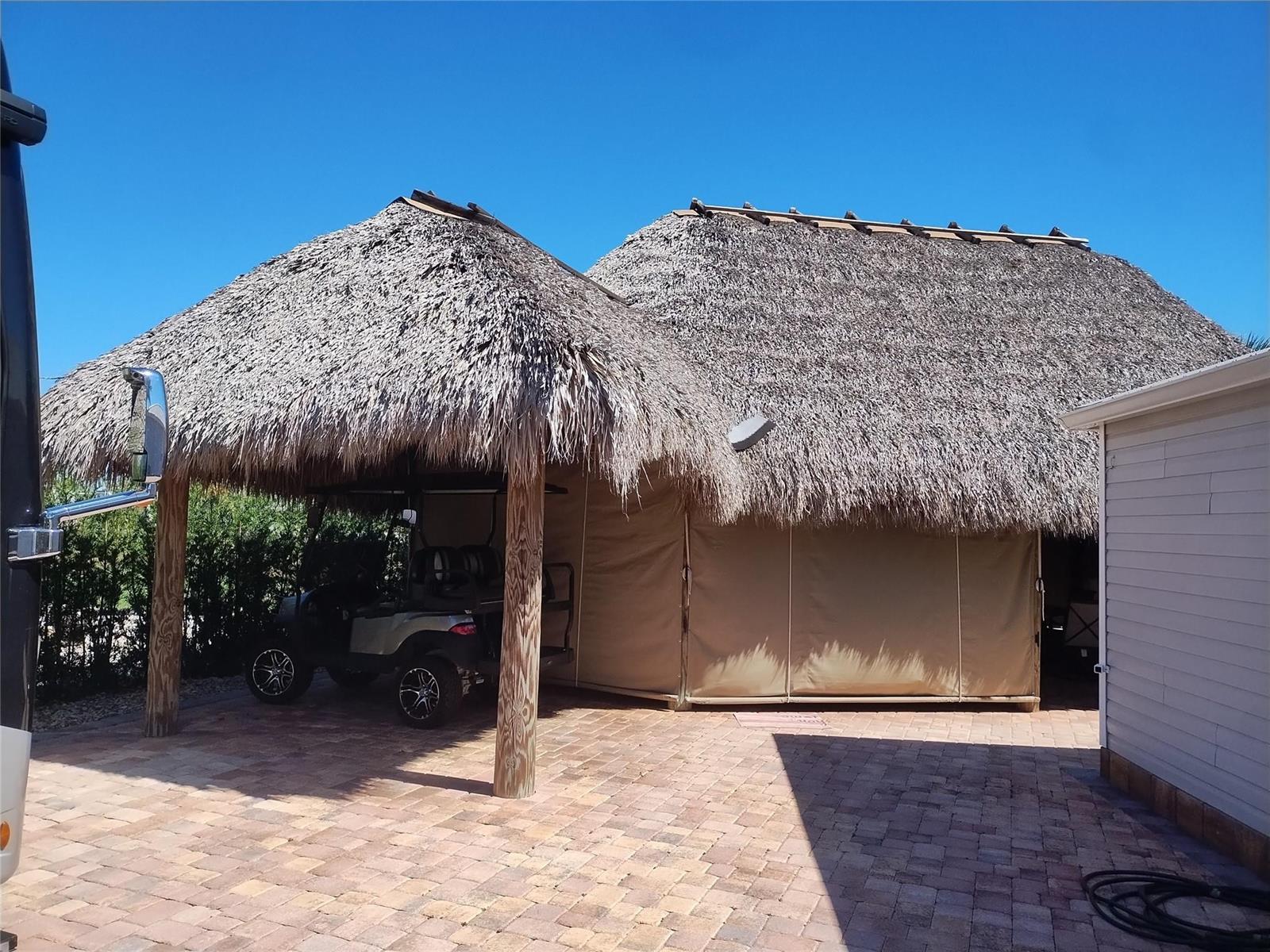 A thatched-roof tiki hut structure covers a golf cart on a paved brick patio — Lot 209 3720 SW 7th Manor, Okeechobee FL 34974, OKEECHOBEE, FL