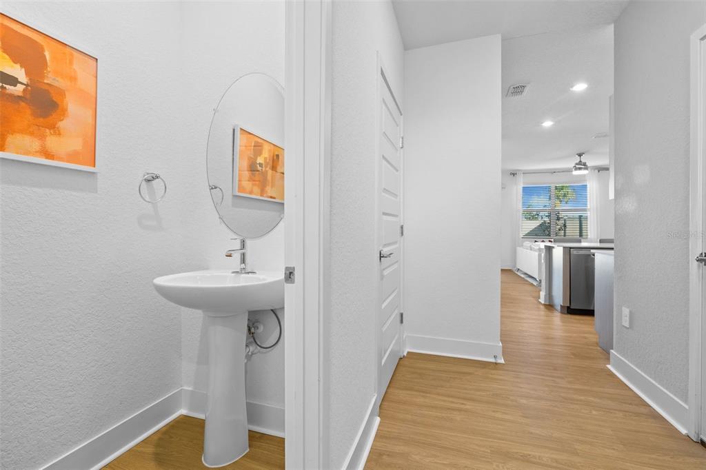 A hallway leads to a kitchen, with a small powder room visible on the left — 14527 STELLAR PLACE, LAKEWOOD RANCH, FL
