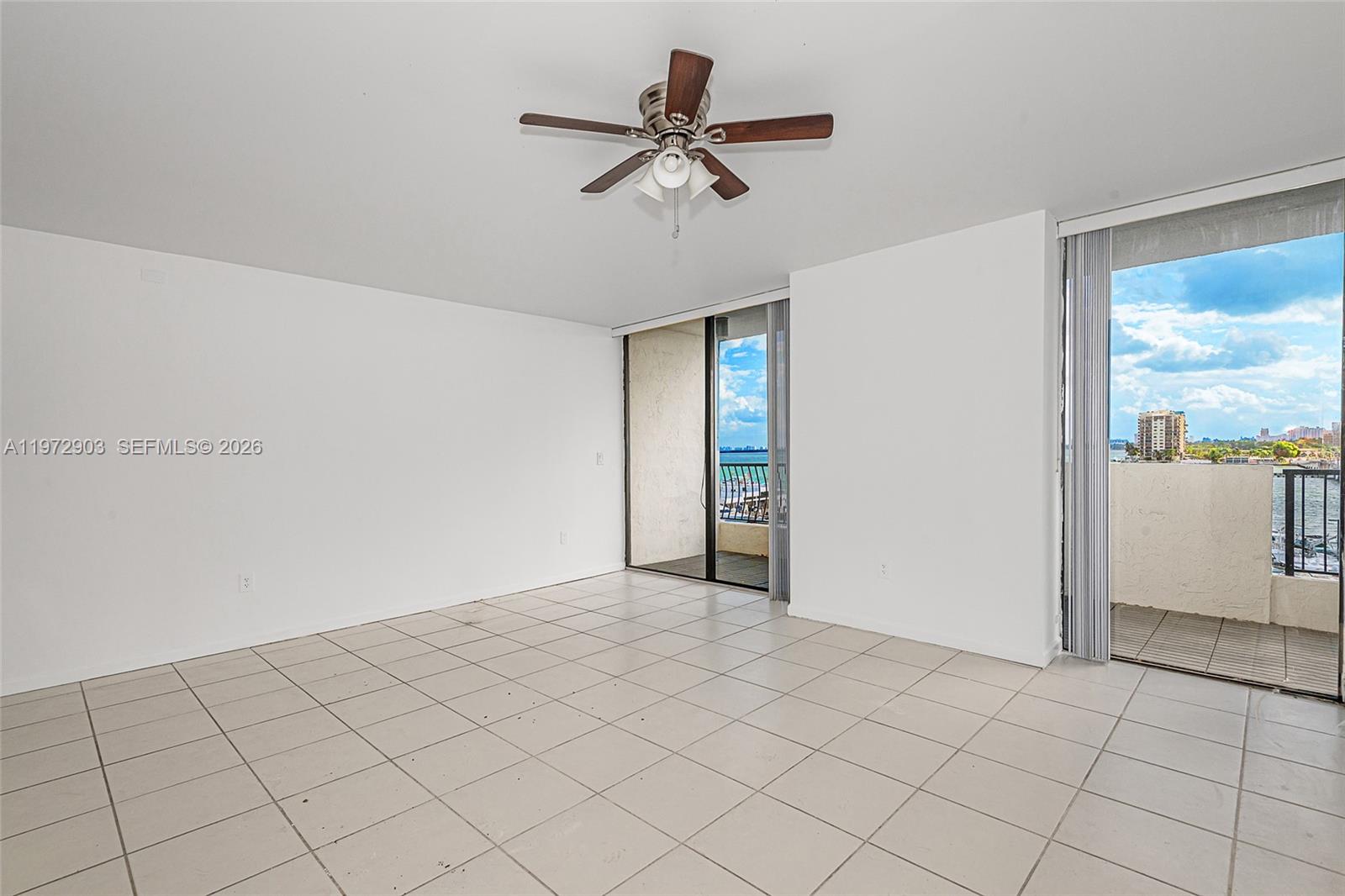 An empty room with white walls, tiled floors, a ceiling fan, and balcony access — 555 NE 15th St # 603, Miami FL 33132, MIAMI, FL