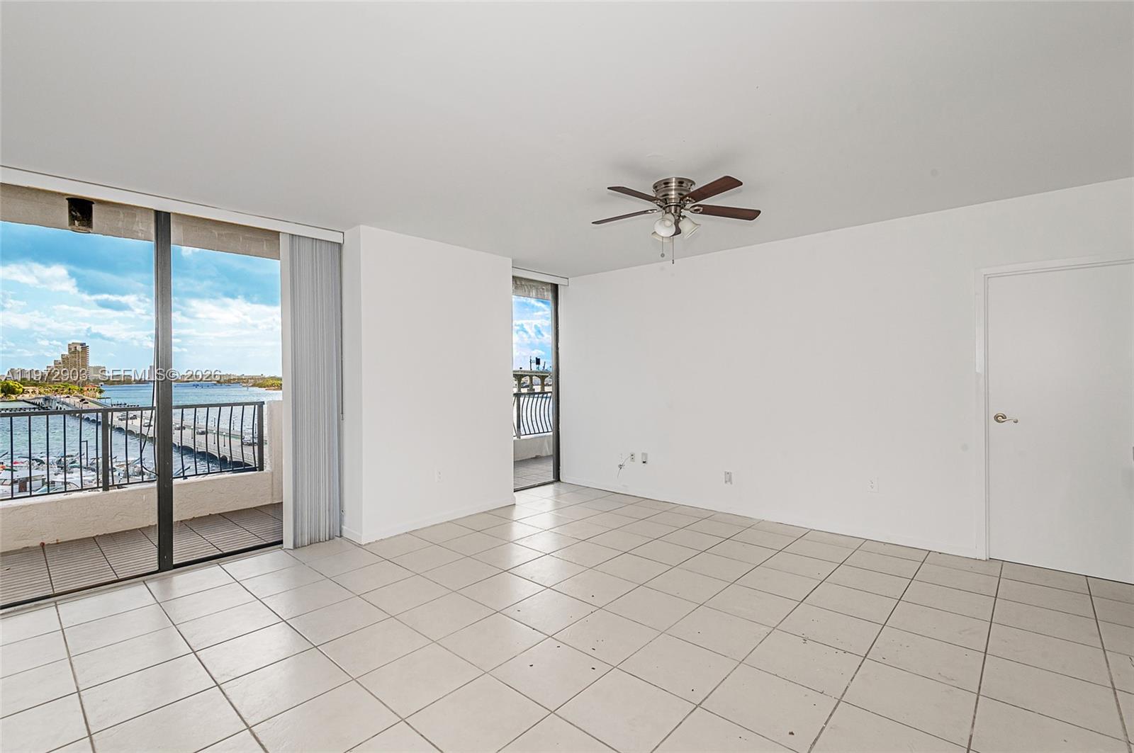An empty room with white walls, tile flooring, a ceiling fan, and sliding glass balcony doors — 555 NE 15th St # 603, Miami FL 33132, MIAMI, FL