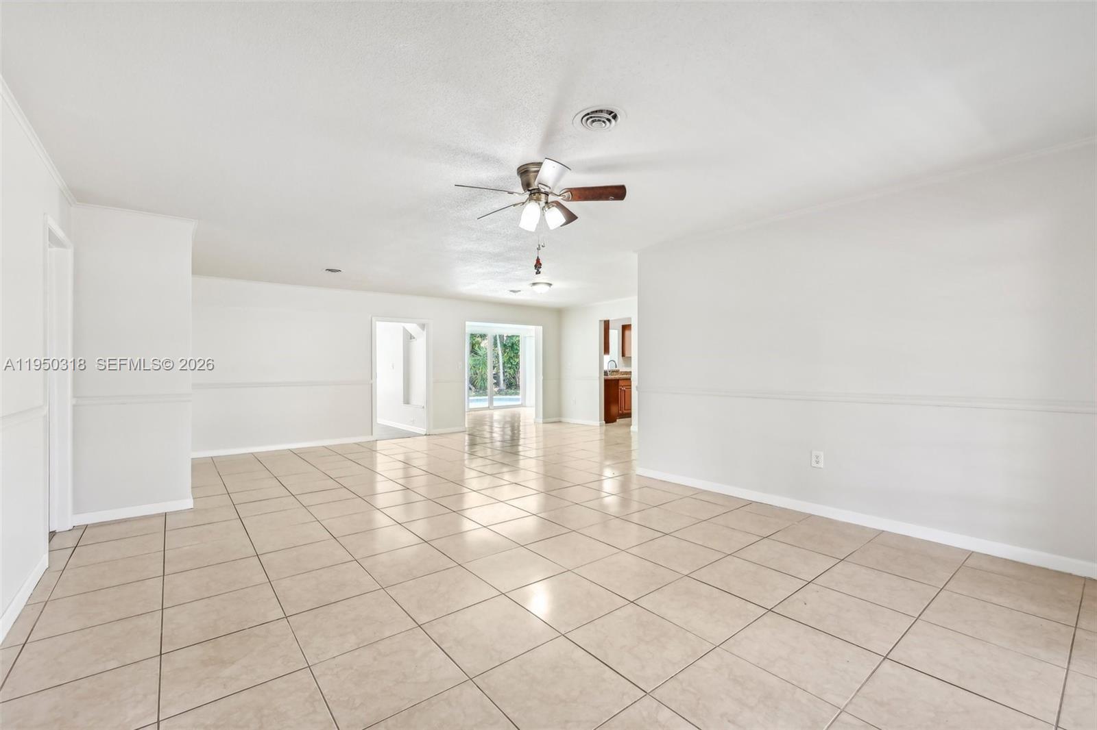 An empty living area features light-colored tile flooring, white walls, and a ceiling fan — 334 NW 12th Ave, Boca Raton FL 33486, BOCA RATON, FL