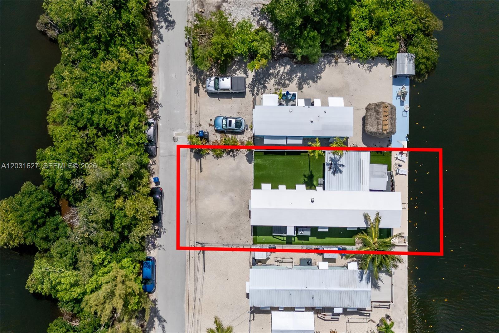 An aerial view shows a waterfront property with a rectangular house, artificial turf, and parking — 456 Bowie Ln, Key Largo FL 33037, KEY LARGO, FL