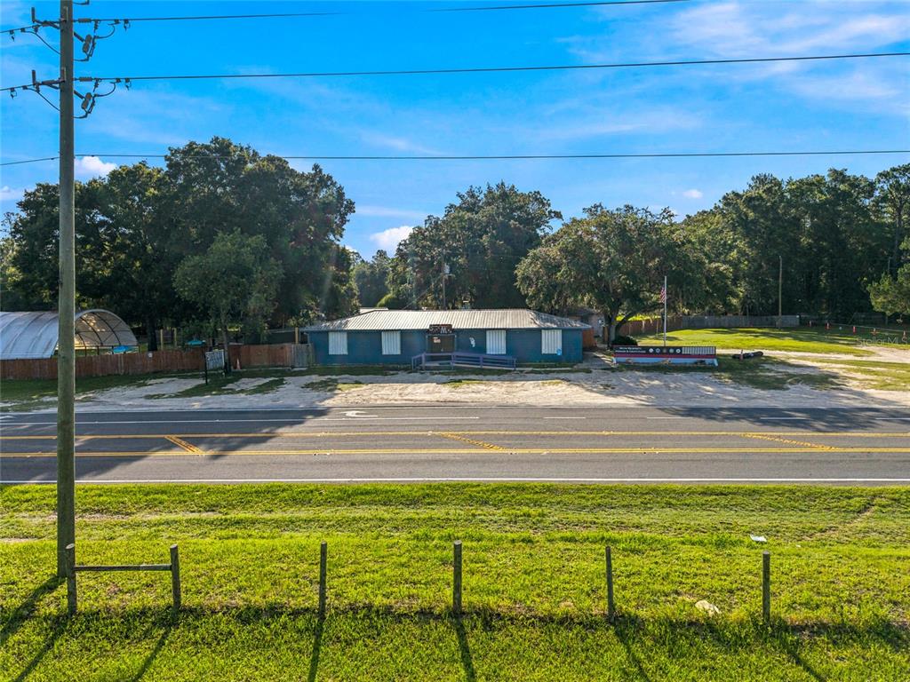 A single-story blue building sits behind a paved road and a grassy foreground — 3025 S US HIGHWAY 41, DUNNELLON, FL