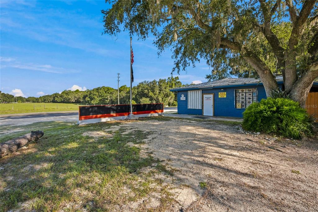 A blue building with a gravel parking area and a flag pole stands outdoors — 3025 S US HIGHWAY 41, DUNNELLON, FL