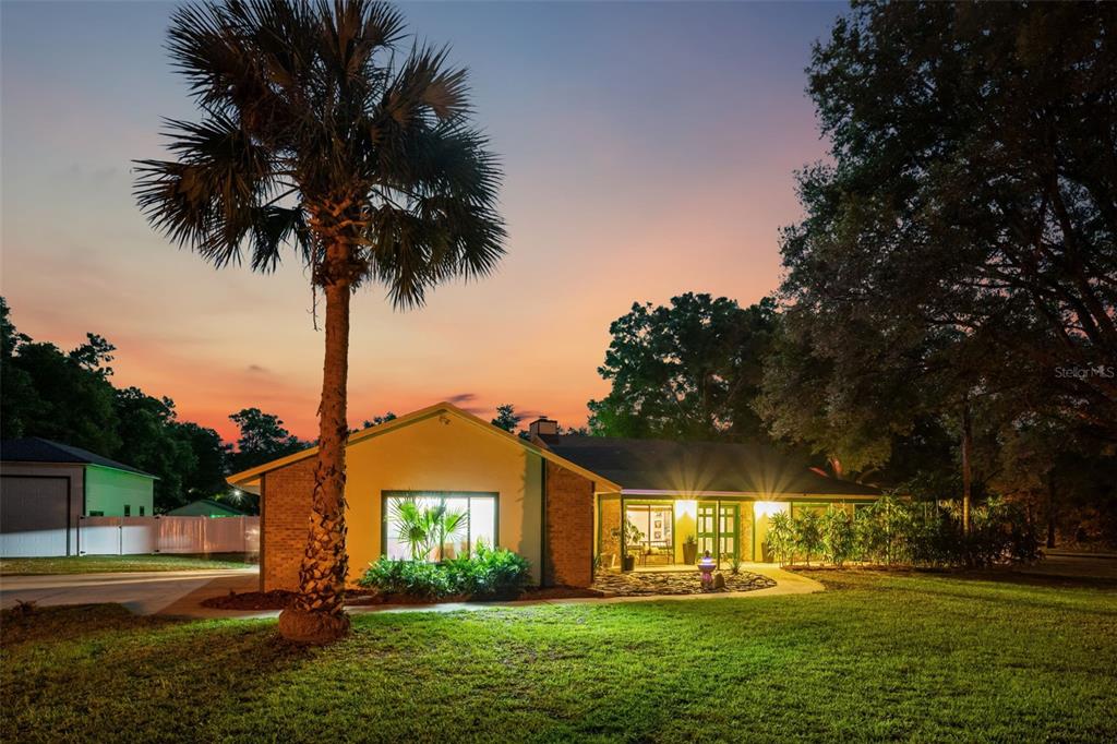 A single-story brick house with a palm tree in the front yard at sunset — 3501 HILL STREAM AVENUE, APOPKA, FL