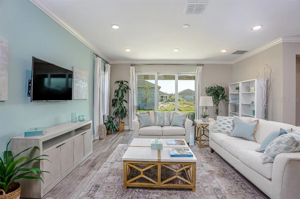 A living room features a light blue accent wall, white sofa, and a wooden coffee table — 26 DOUGLAS COURT S, HOMOSASSA, FL
