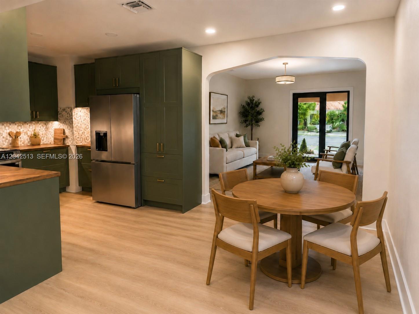 A kitchen with green cabinets and wood countertops opens into a dining and living area — 3053 SW 21st St, Miami FL 33145, MIAMI, FL