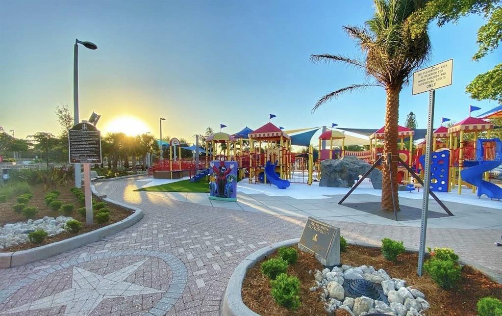 A sunny outdoor playground features colorful climbing structures, slides, and paved walkways with landscaping — 336 LIME AVENUE, SARASOTA, FL