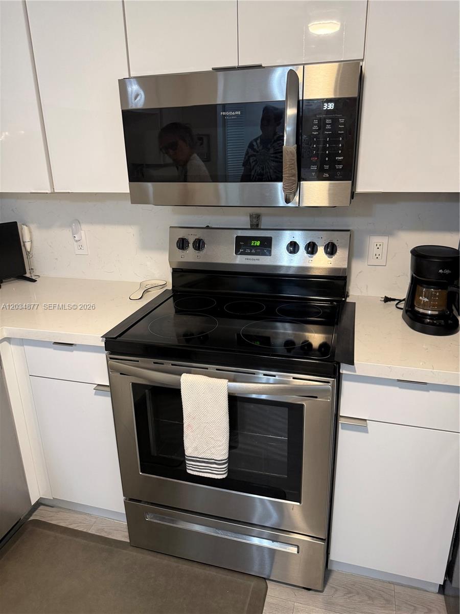 A kitchen features white cabinets, stainless steel appliances, and a quartz countertop — 10312 NW 24th Pl # 106, Sunrise FL 33322, SUNRISE, FL