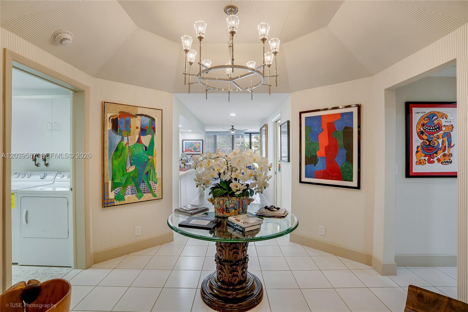 A foyer features a glass-topped pedestal table, a chandelier, and artwork on striped wallpapered walls — 2100 S Ocean Boulevard # 103N, Palm Beach FL 33480, PALM BEACH, FL
