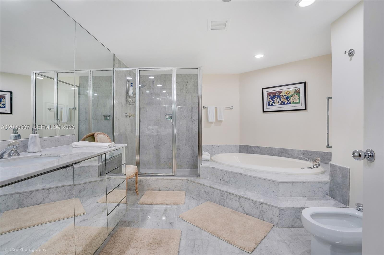 A bathroom features a marble-tiled shower, a raised soaking tub, and a mirrored vanity — 2100 S Ocean Boulevard # 103N, Palm Beach FL 33480, PALM BEACH, FL