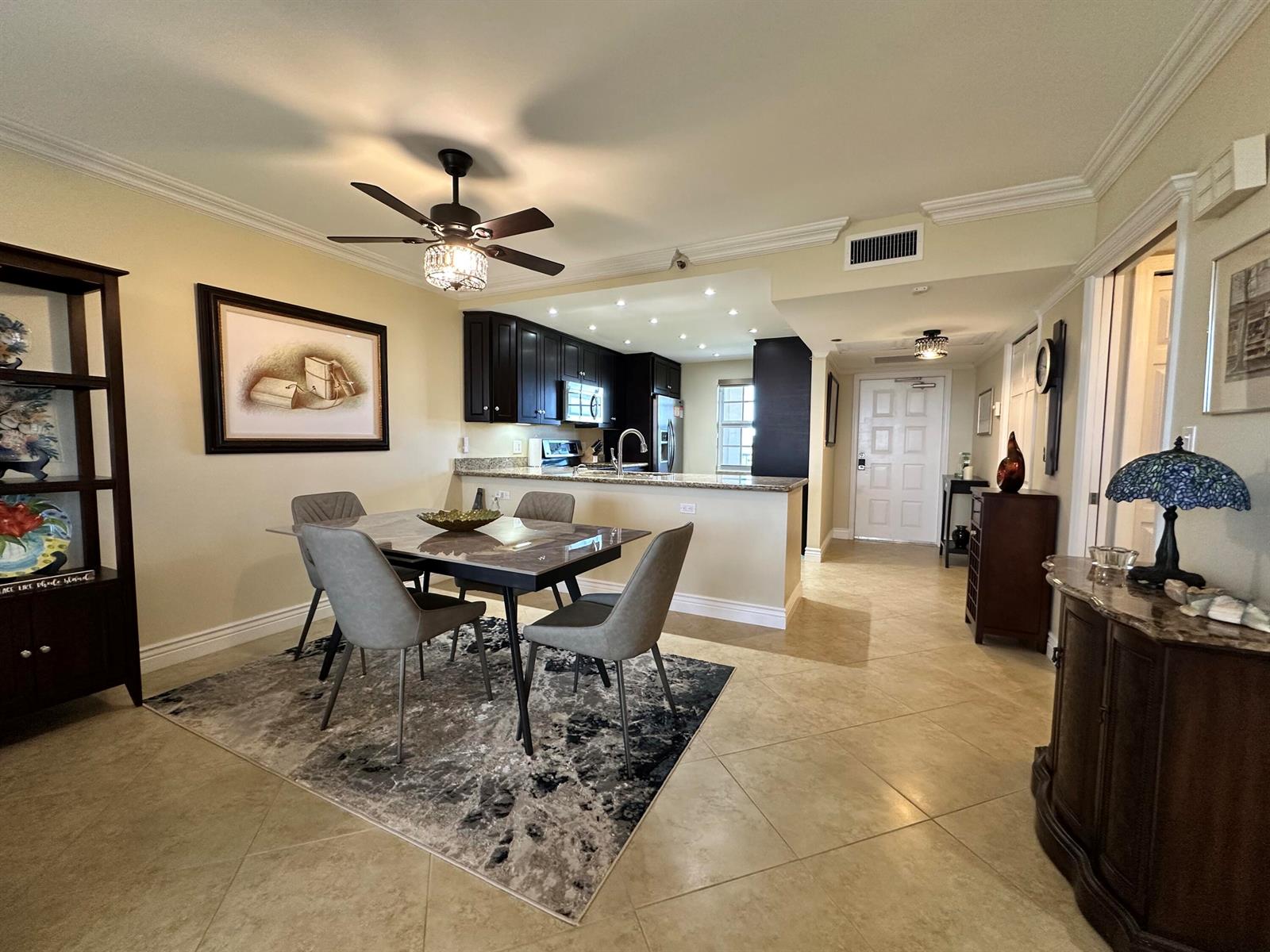 A dining area with a table and chairs sits adjacent to an open kitchen — 3507 Oaks Way # 905, Pompano Beach FL 33069, POMPANO BEACH, FL