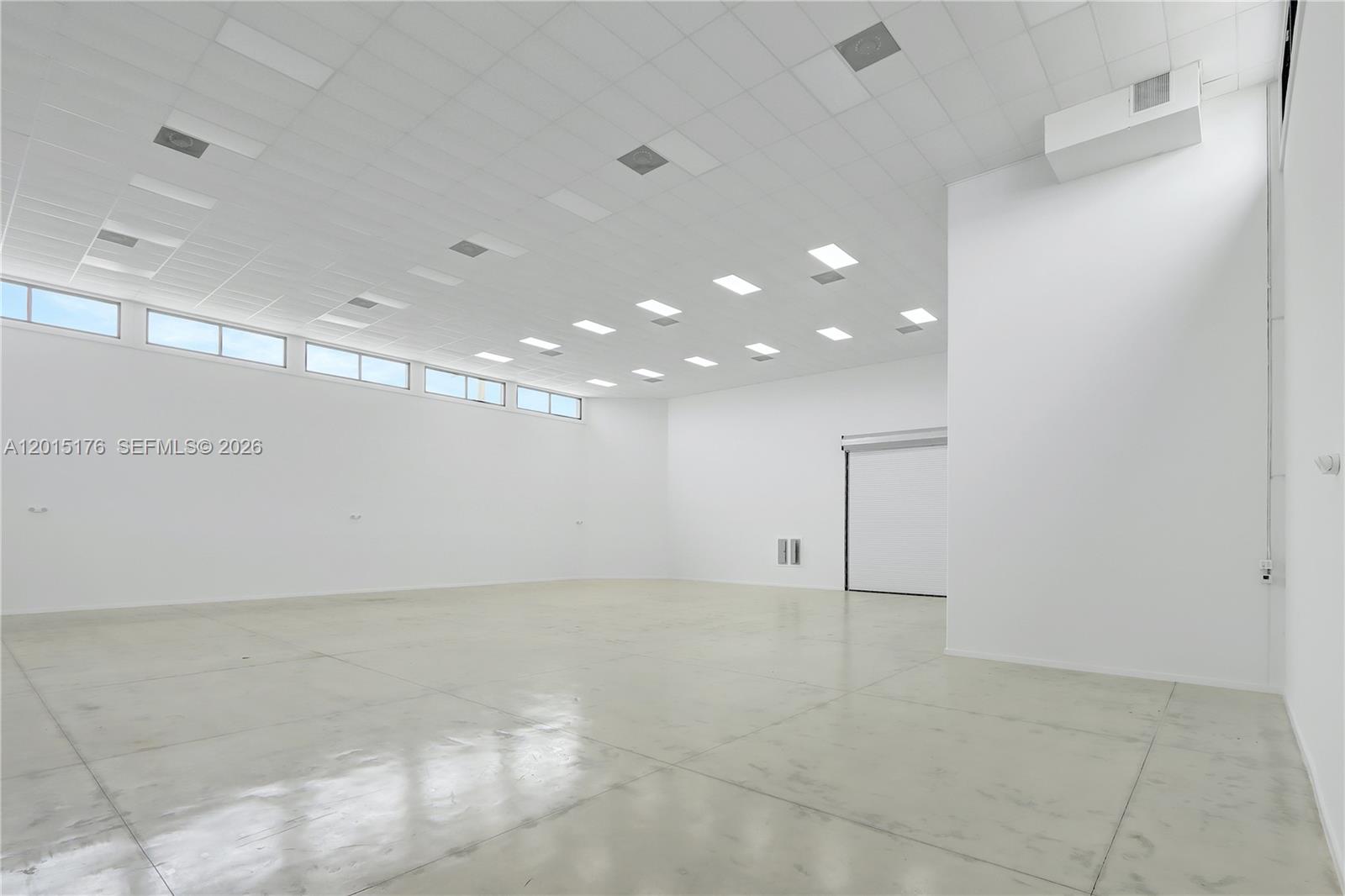 An empty, white-walled commercial space features a high drop ceiling, recessed lighting, and polished floors — 6767 NE 2nd ave, Miami FL 33138, MIAMI, FL