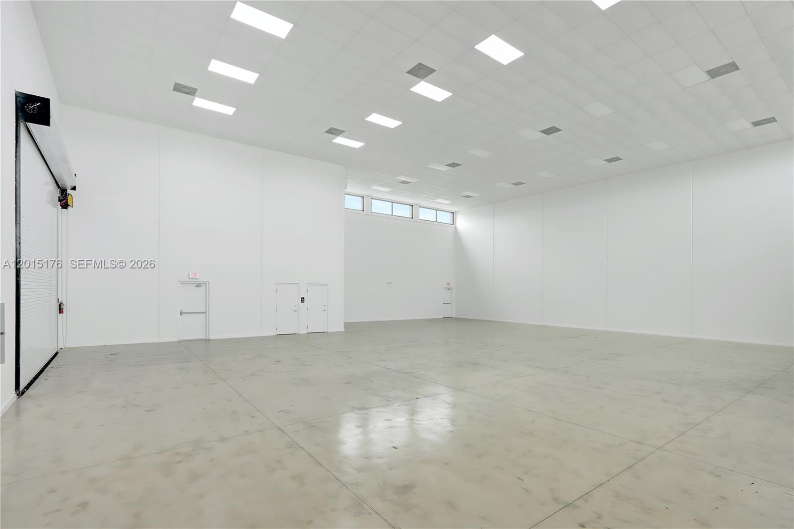 A large, empty warehouse space features white walls, a concrete floor, and recessed ceiling lights — 6767 NE 2nd ave, Miami FL 33138, MIAMI, FL