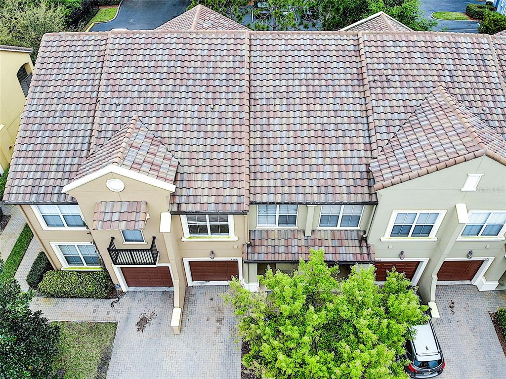 An aerial view shows the tiled roofs and front facades of several attached townhomes — 3660 IDITAROD LANE, ORLANDO, FL