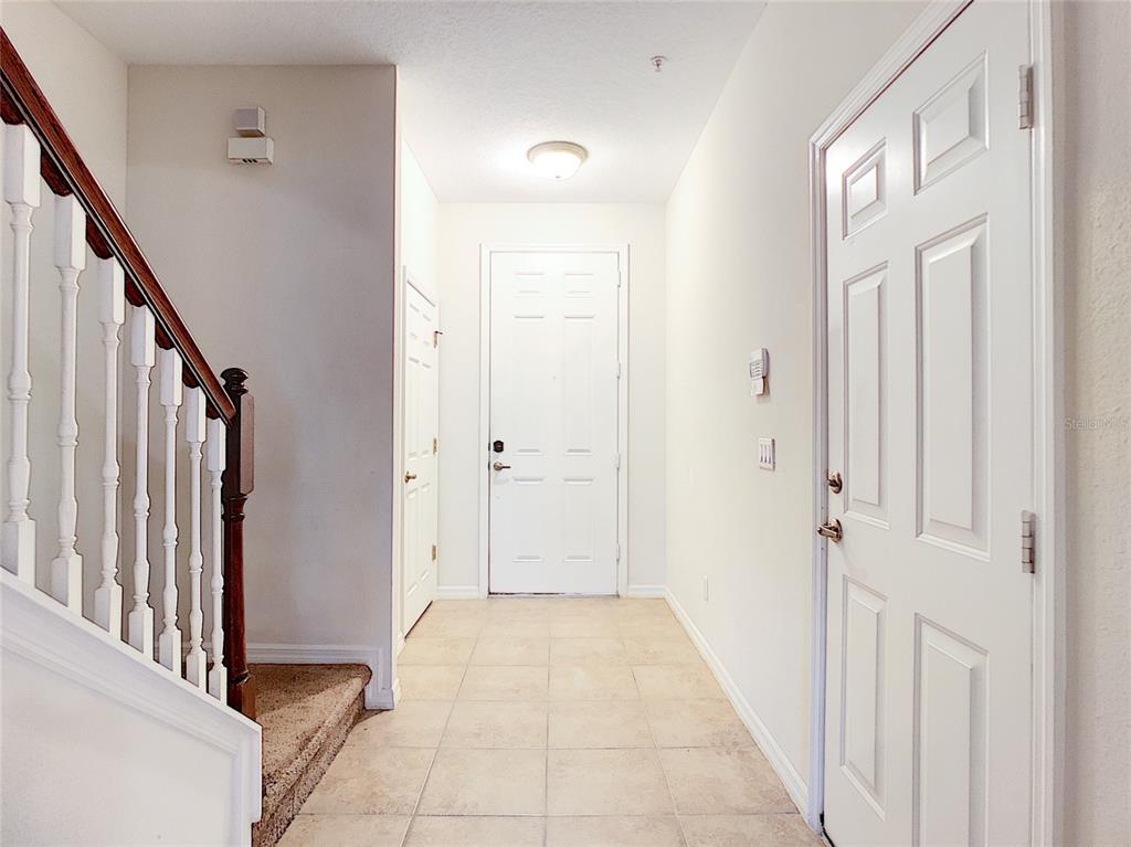 An entryway features tile flooring, a staircase with a wooden railing, and white interior doors — 3660 IDITAROD LANE, ORLANDO, FL