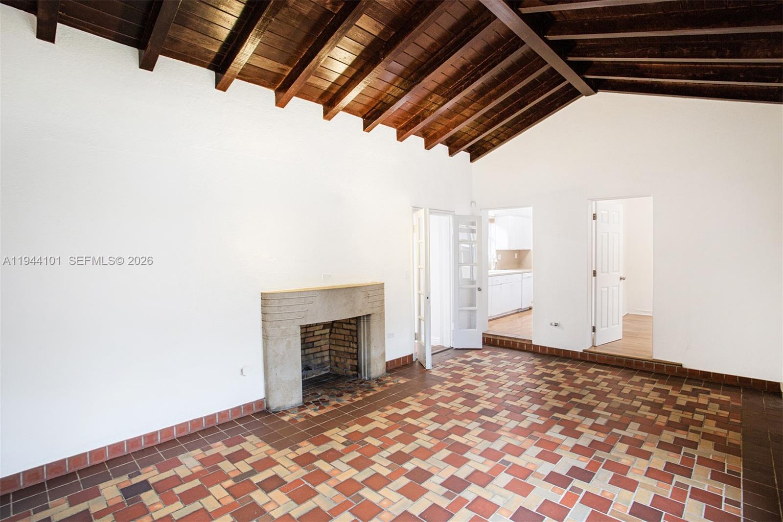A living room features a stone fireplace, tiled floor, and exposed wood beam ceiling — 236 SW 28th Rd, Miami FL 33129, MIAMI, FL