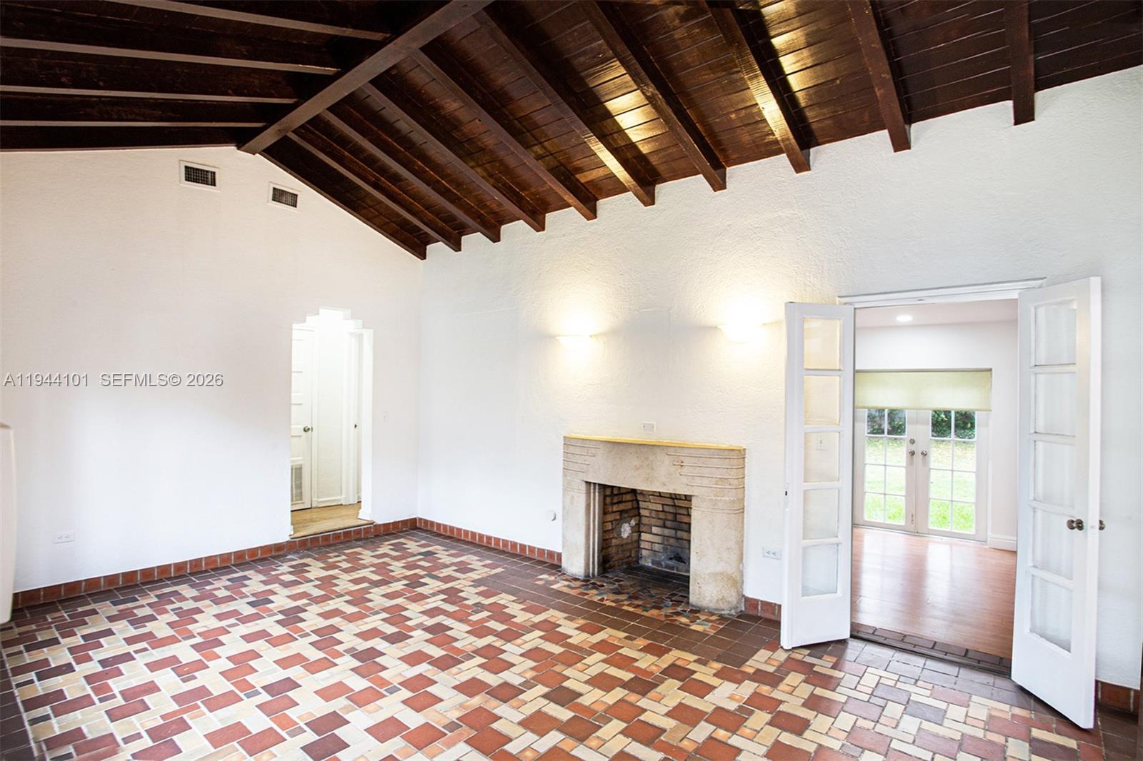 A living room features a vaulted wood-beam ceiling, a stone fireplace, and patterned tile flooring — 236 SW 28th Rd, Miami FL 33129, MIAMI, FL