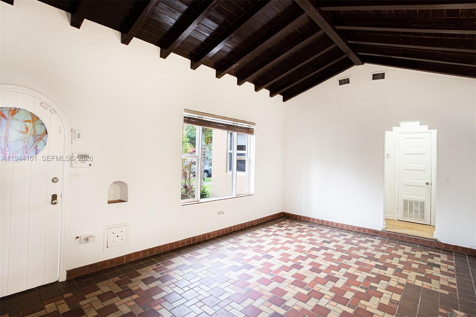 A room with a vaulted wood-beamed ceiling, tiled floor, and a stained-glass front door — 236 SW 28th Rd, Miami FL 33129, MIAMI, FL