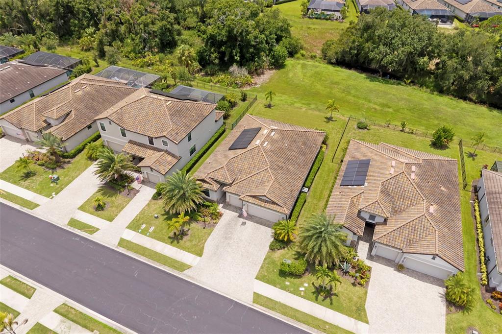 An aerial view of several suburban houses with tiled roofs and driveways along a street — 17927 POLO TRAIL, BRADENTON, FL