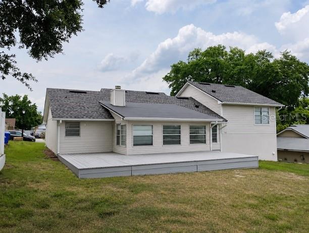 A light-colored house features a large gray deck and a dark shingled roof — 9120 QUEEN ELIZABETH COURT, ORLANDO, FL