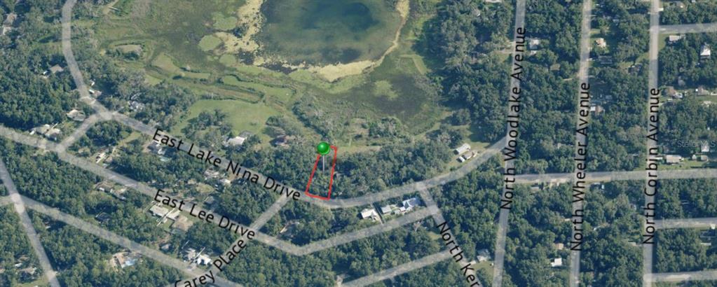 An aerial view shows a vacant lot outlined in red near a lake and roads — 3579 E LAKE NINA DRIVE, INVERNESS, FL