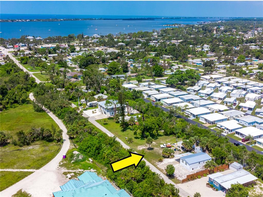 An aerial view shows a residential property with a yellow arrow pointing toward a vacant lot — 240 RIVERVIEW AVENUE, ENGLEWOOD, FL