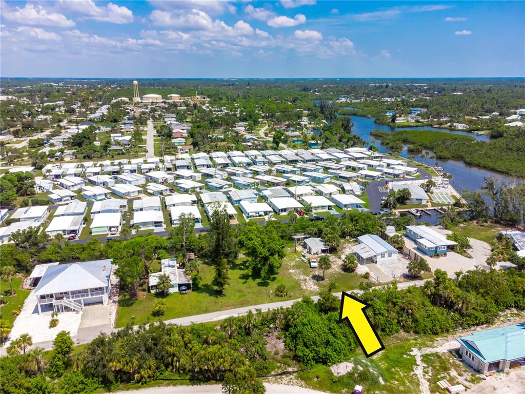 An aerial view shows a residential neighborhood with mobile homes and houses near a waterway — 240 RIVERVIEW AVENUE, ENGLEWOOD, FL