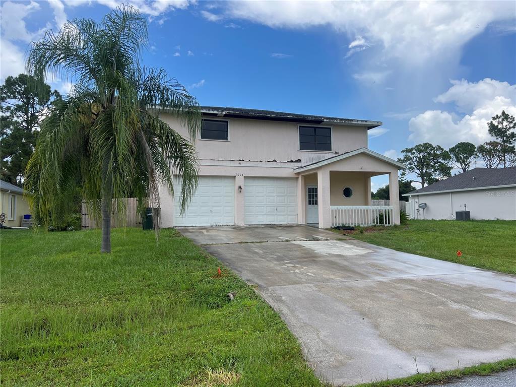 A two-story house with a two-car garage, a front porch, and a concrete driveway — 3774 LORTON AVENUE, NORTH PORT, FL