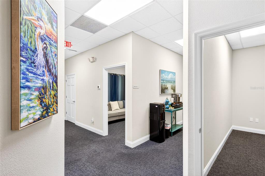 A hallway with gray carpet leads to an office, a break station, and a doorway — 365 WEKIVA SPRINGS ROAD UNIT Suite 201 and 222, LONGWOOD, FL