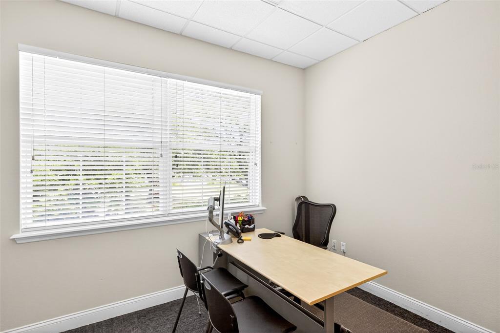 A small office features a light wood desk, two black chairs, and a large window — 365 WEKIVA SPRINGS ROAD UNIT Suite 201 and 222, LONGWOOD, FL