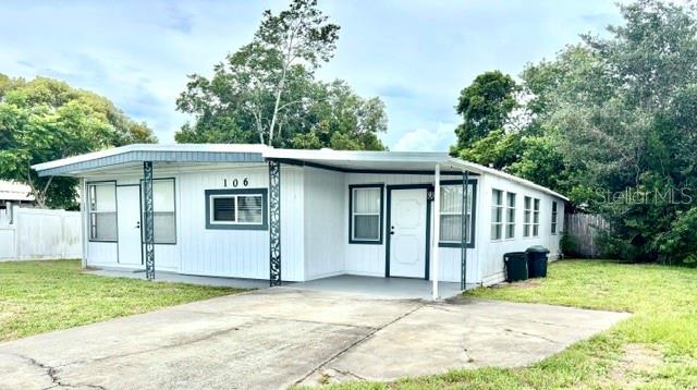 A single-story white mobile home with a concrete driveway and a covered front porch — 106 ALOHA TERRACE, PORT ORANGE, FL