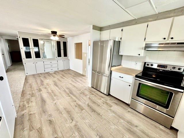 A kitchen with white cabinets, stainless steel appliances, and light wood-look flooring — 106 ALOHA TERRACE, PORT ORANGE, FL