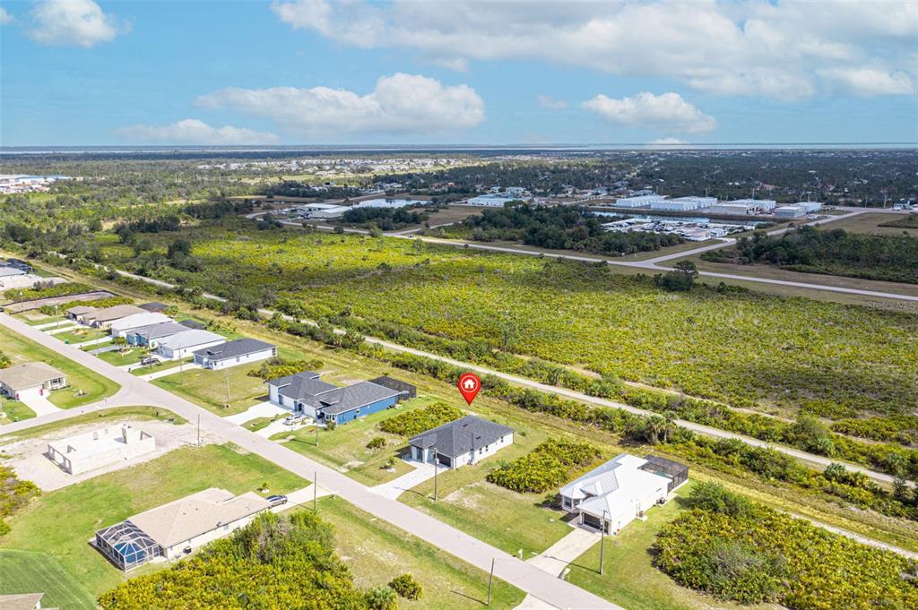An aerial view shows a single-story house with a dark roof in a suburban neighborhood — 384 BAYTREE DRIVE, ROTONDA WEST, FL
