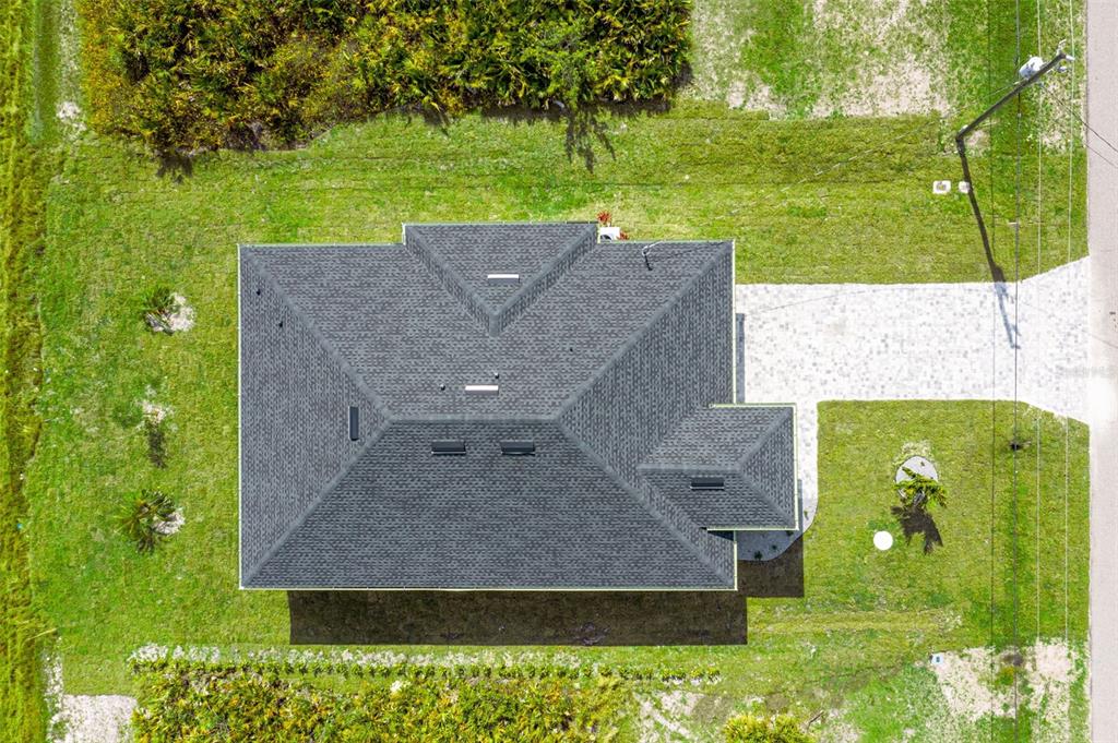 An aerial view shows a house with a dark shingled roof and a paved driveway — 384 BAYTREE DRIVE, ROTONDA WEST, FL
