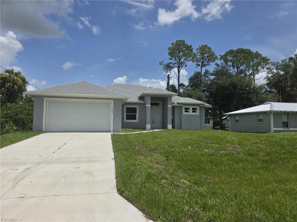 A gray single-story house features a two-car garage and a concrete driveway — 3852 HOPEVALE STREET, FORT MYERS, FL