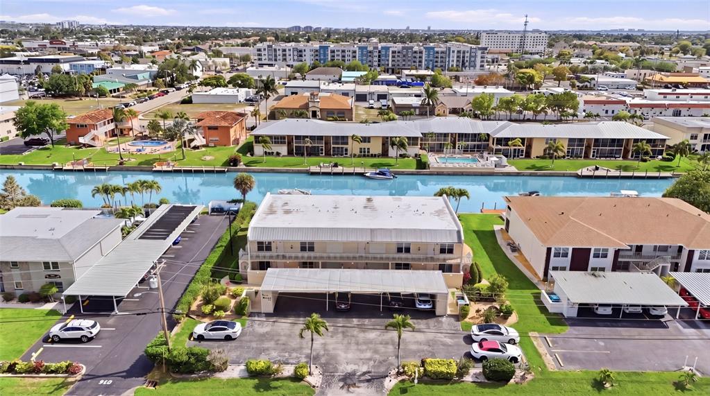 An aerial view shows a multi-story apartment building with a canal and parking area — 912 SE 46TH STREET UNIT 201, CAPE CORAL, FL