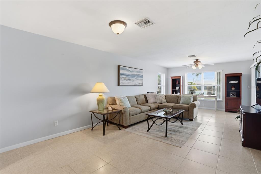 A living room features a beige sectional sofa, a coffee table, and tile flooring — 912 SE 46TH STREET UNIT 201, CAPE CORAL, FL